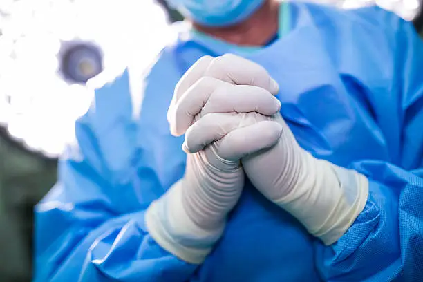 Photo of Surgeon praying in operation room while operation