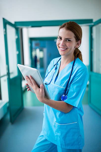 istock Portrait of surgeon using digital tablet in corridor 629772060