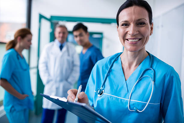 istock Portrait of smiling surgeon writing on clipboard 629772196