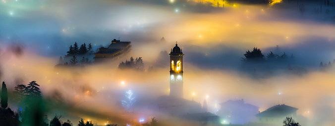 Fog over a country with bell tower