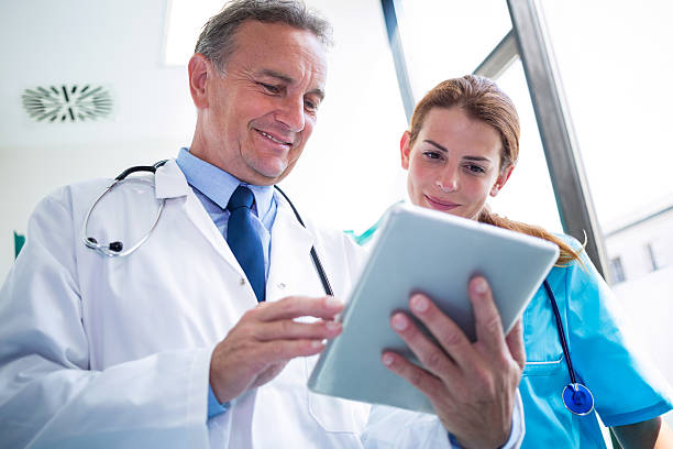 istock Doctor and nurse discussing over digital tablet 629775026