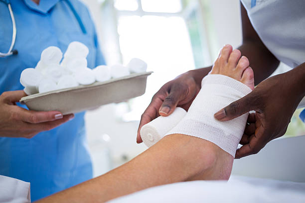 istock Doctor bandaging patients leg 629778064