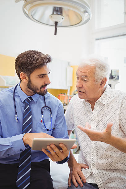 Doctor discussing with patient over digital tablet