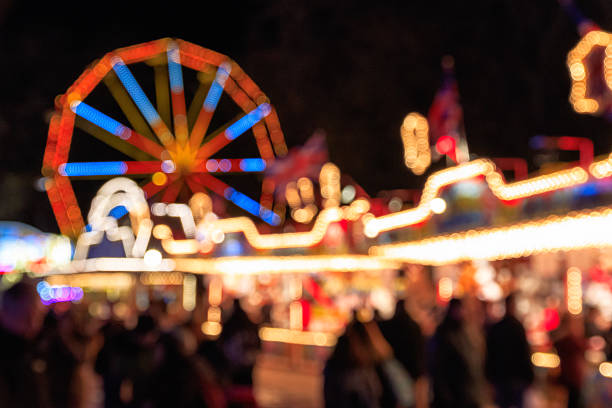 luci festive sfocate del paese delle meraviglie invernale - parco dei divertimenti ambulante foto e immagini stock