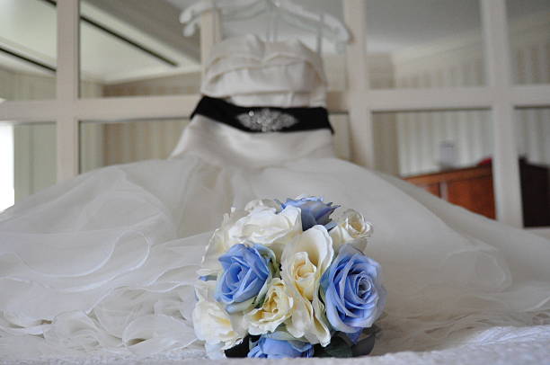 istock Wedding Bouquet on Bed with Wedding Dress on Mirror Headboard 629781310