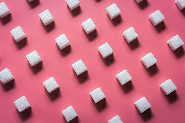 Pattern Sugar Cubes on a Pink Background Pattern Sugar Cubes on a Pink Background sugar cube stock pictures, royalty-free photos & images