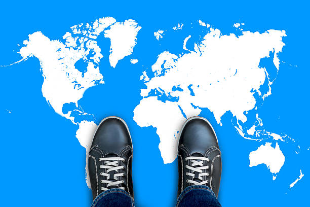 istock Black casual shoes standing on world map 629786284