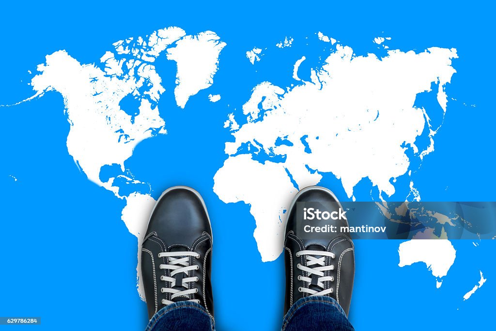 Black casual shoes standing on world map Black casual shoes standing on world map start making his journey around the world. In Front Of Stock Photo