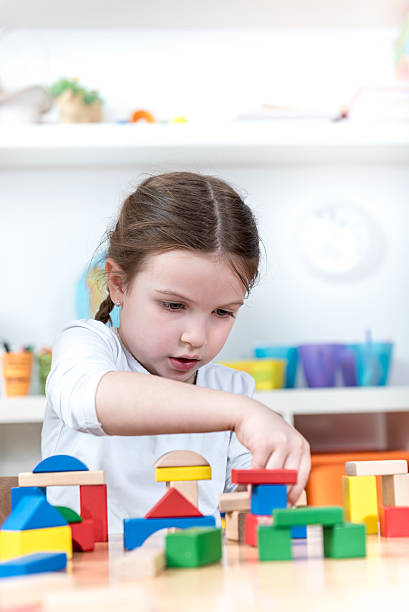 istock cute girl plays with building blocks her room 629786892