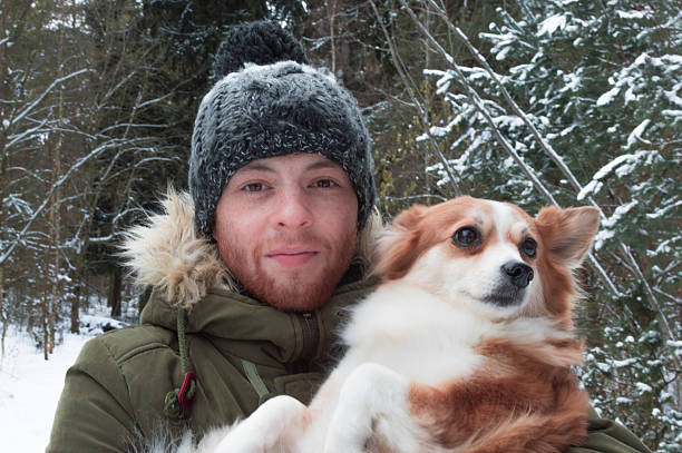 istock one man with a dog in winter forest 629786936