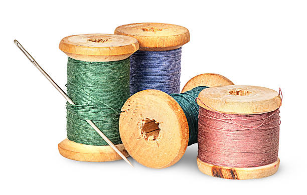 Needle and multicolored thread on wooden spool Needle and multicolored thread on wooden spool isolated on white background wooden spool stock pictures, royalty-free photos & images