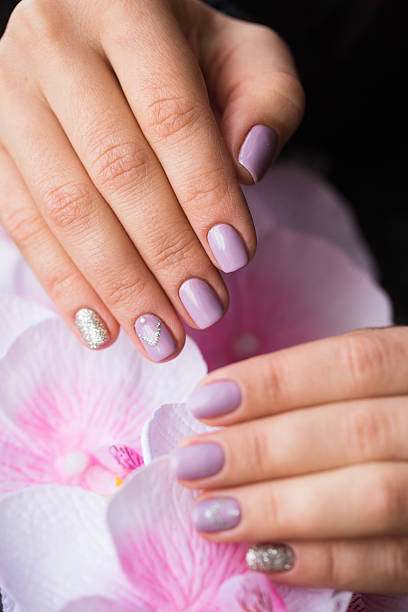 istock Hand with manicured nails on a pink background flowers 629789842