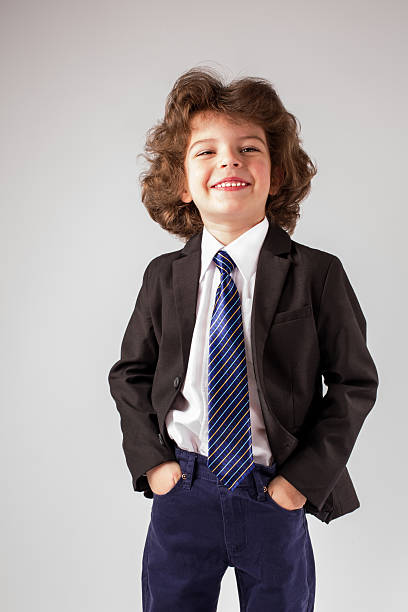 istock Little boy smiles sweetly bowing his head looking up. 629792104