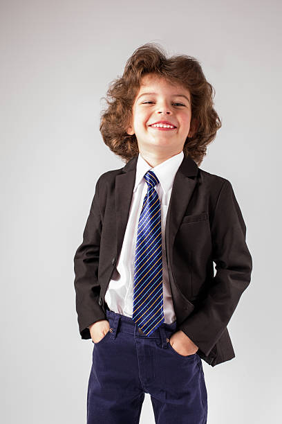 istock Little boy smiles sweetly bowing his head looking at camera. 629792434