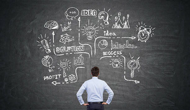 istock businessman looking at a large chalk sketch 629793672