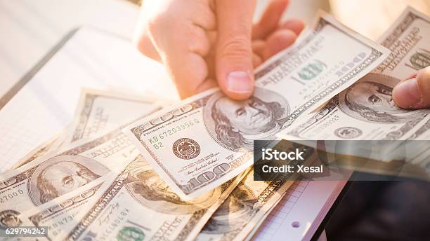 Hands Counting Us Dollars With Calculator And Digital Tablet Stock Photo - Download Image Now