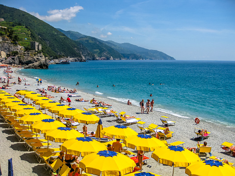 Monterosso al Mare, Ligurian Coast, Italy - June 4, 2010: colorful beach umbrella at the Monterosso beach in Cinque Terre National Park.