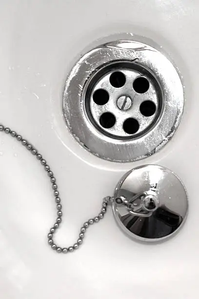 Chrome sink Plughole and stopper on a chain.