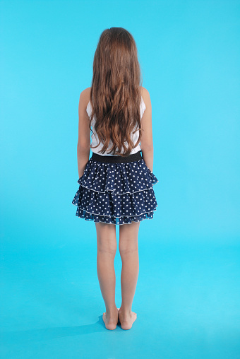 Girl with beautiful natural brown hair isolated on blue