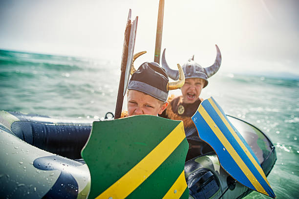 Kids playing vikings at sea on a boat Two fearsome little vikings are attacking enemy, Two boys aged 6 are playing vikings at sea,  viking ship photos stock pictures, royalty-free photos & images