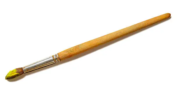 Close-up of a paintbrush with yellow paint. Isolated on a white background.