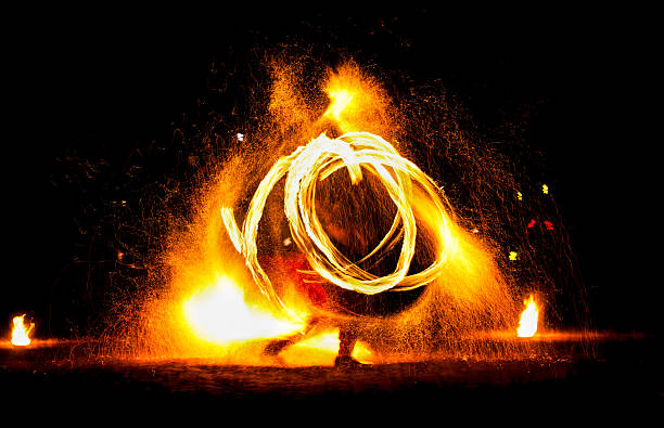 istock Man entertains the audience with the help of fire. 629801330