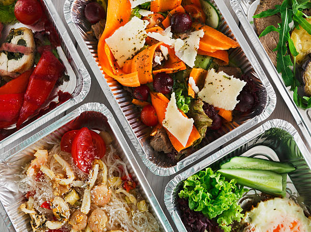 Healthy food take away, top view at wood background Healthy food background. Take away of natural organic food in foil boxes. Fitness nutrition, meat, rice vermicelli, vegetable salads and eggs. Top view, flat lay. box container stock pictures, royalty-free photos & images