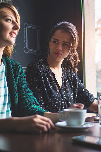 istock Beautiful smiling and young women drinking a coffee in caffe 629806558
