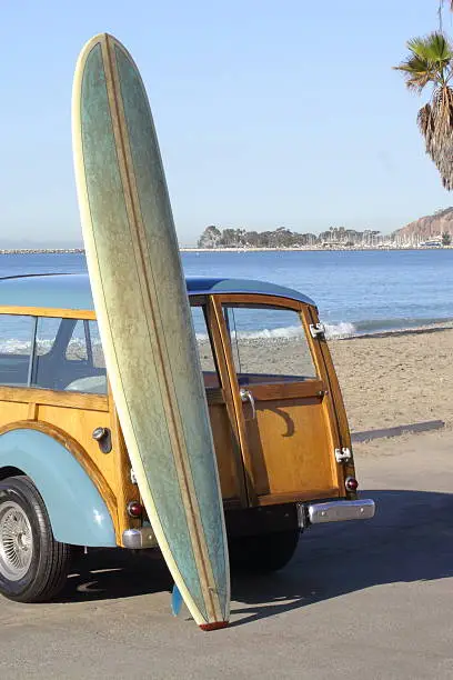 MY surfboard leaning against my little woody, waiting for a set to come in at Doheny State Beach.