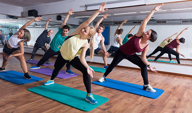 istock men and ladies learning yoga 629809634