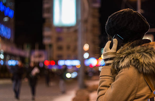 istock Girl talking on mobile phone at night in winter 629814546