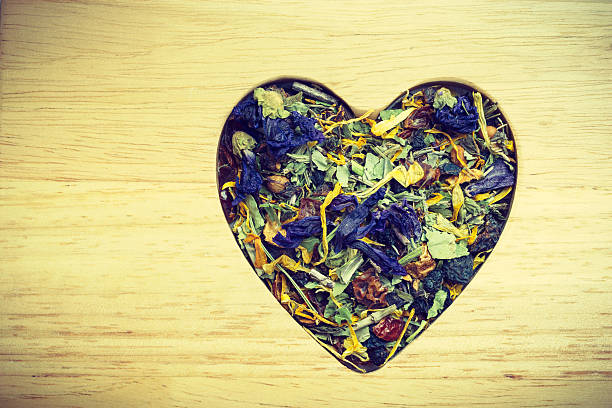 istock Dried herb leaves heart shaped on wooden surface 629814656