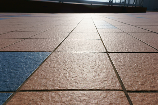 patterned paving tiles, cement brick floor background and sunlight