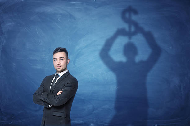 istock Businessman standing and shadow on the blackboard behind him holding 629817534