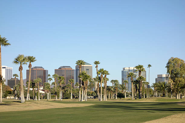 View at Phoenix Downtown from Encanto Park green lawns, Arizona; Copy space in clear blue sky