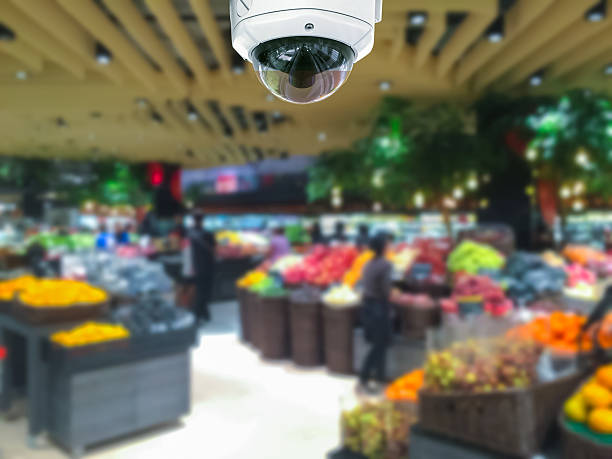CCTV camera security in shopping mall with supermarket blur back stock photo