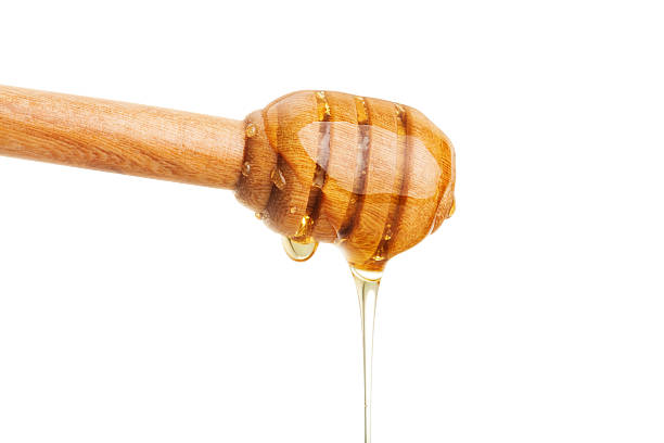 istock Honey dripping from wooden dipper stick. 629821650