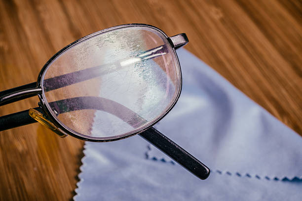 Old Eyeglass with many scratches and blue microfiber cloth stock photo
