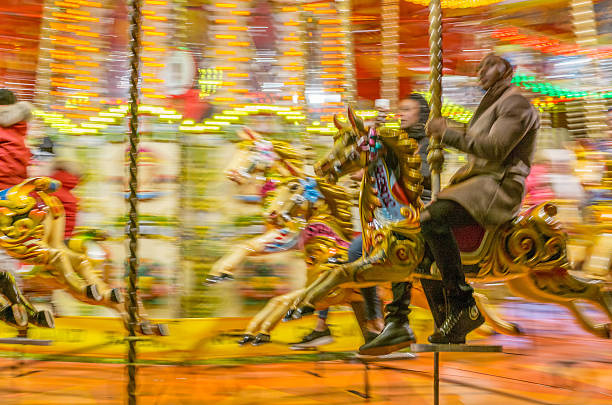 London, UK - December 4, 2016: Black couple riding carousel roundabout motion blur located on the banks of the River Thames.