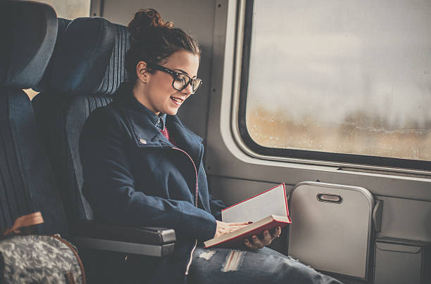 istock Young woman reading on a train 629829330