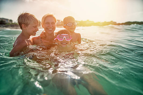 istock Mother having fun splashing in sea waves 629829348