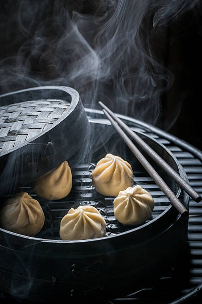 Enjoy your chinese dumplings in wooden steamer Enjoy your chinese dumplings in wooden steamer chinese dumpling stock pictures, royalty-free photos & images