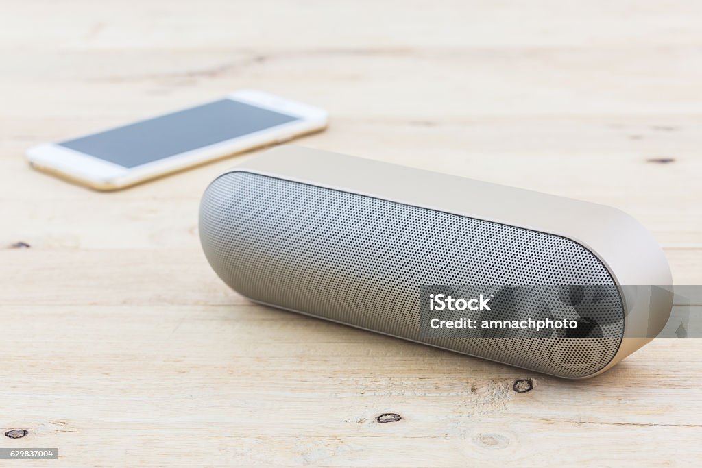 Wireless speaker for mobile phone, Speaker for smartphone. Wireless speaker for mobile phone, Speaker for smartphone on wood desk Background. Speaker Stock Photo