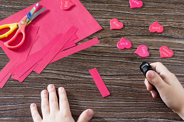 istock The child makes crafts garland for Valentine's Day. 629863774