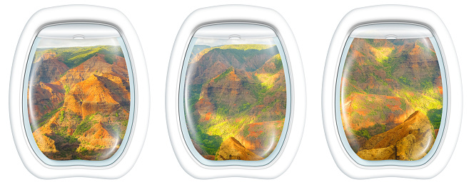 Three plane windows on colorful Waimea Canyon State Park, also called Grand Canyon of Pacific, at sunset in Kauai, Hawaii, United States, from a plane on the porthole windows. Copy space.