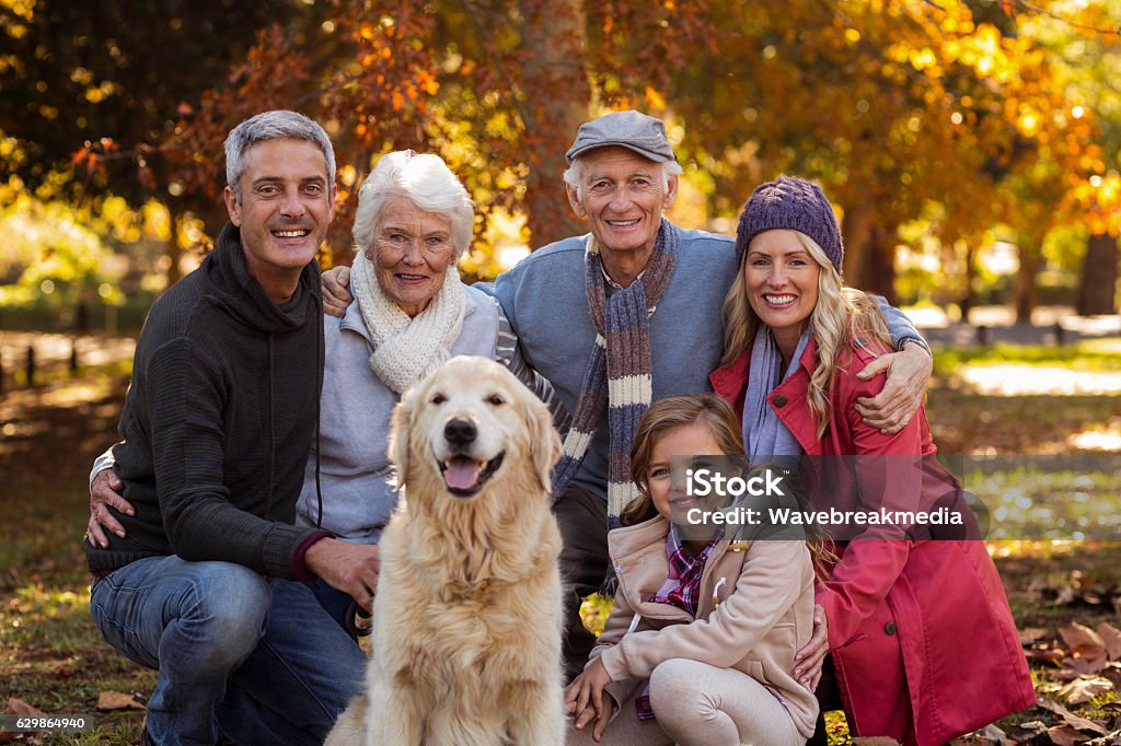 Multi-generation family with dog at park Portrait of multi-generation family with dog at park during autumn Family Stock Photo