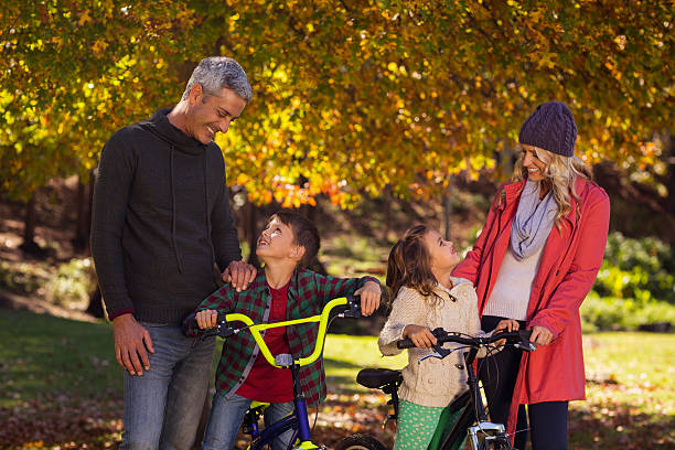 istock Happy children riding bicycles with parents 629865894
