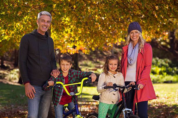 istock Children riding bicycles with parents at park 629865938