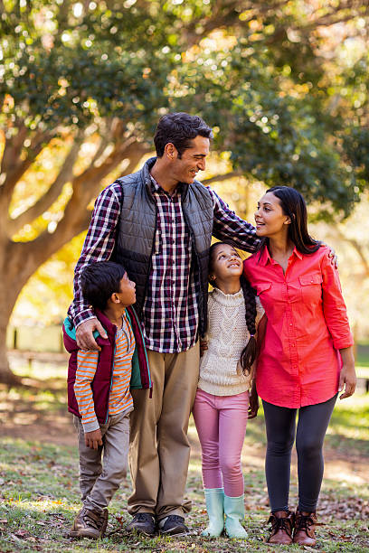 istock Front view of smiling family standing at park 629866506