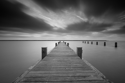 Jetty at lake Markermeer in black and white.